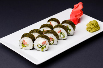 Sushi large set served on a white plate over white background. Traditional Asian Japanese cuisine concept.