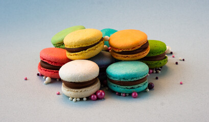 Multicolored macarons with beads on a gray background.