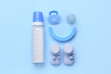 Bottle of milk for baby and accessories on color background