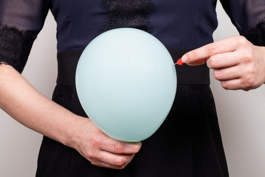 Bloated Stomach. Pain and health problems. Woman with a blue balloon and a needle