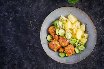 Steamed fish fillet with tomatoes sauce, boiled potatoes and fresh cucumber salad. Diet meal....