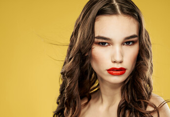 Beautiful brunette with red lips eyeshadow and yellow background