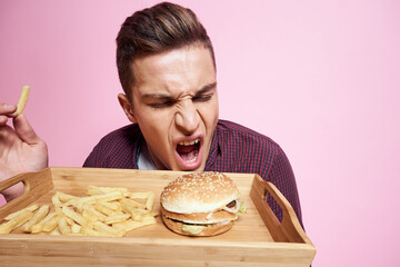 man in shirt french fries and hamburger pink background emotions