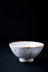 Traditional ceramic bowl on dark background. Close up. Copy space. 