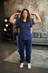 young female doctor in blue surgical suit. Girl with big muscles
