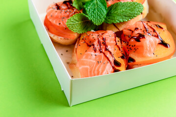 Italian Appetizer Bruschetta with salmon in white delivery box, take away concept.