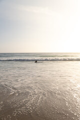 Surfista en el mar grabándose a sí mismo con una cámara de acción pegada a la tabla de surf 