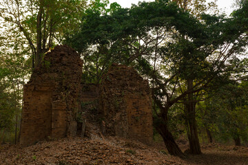 Fototapeta na wymiar Ruins of goal kampong tom Wat Temple with root of trees in forest Cambodia.