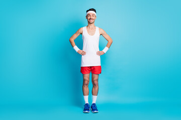 Fototapeta na wymiar Full length photo of sporty man hold hand waist wear white singlet gumshoes isolated over blue color background