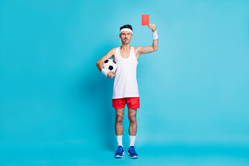 Full length photo of displeased person arm hold ball demonstrate red card isolated on blue color...