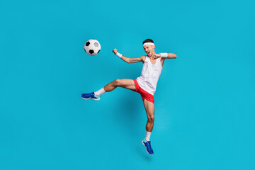 Fototapeta na wymiar Full size portrait of young guy open mouth shout jumping leg kick ball wear long socks isolated on blue color background