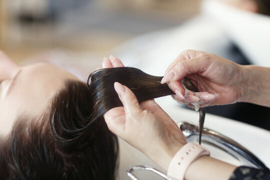 hairdresser hand washing hair on client closeup photo in hair salon