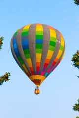Bright colored beautiful hot air balloon fly on blue sky background of Pamukkale in Turkey. Vertical shot.