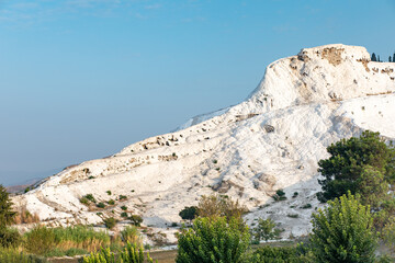 White calcite mountain in Pamukkale, Turkey on background blue sky.