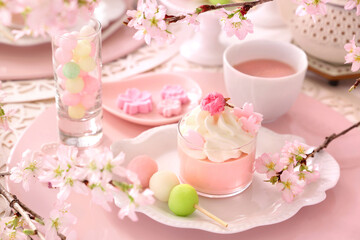 Spring dessert plate with cherry blossom mousse and Three color dumplings.
Beautiful cherry blossom background.　手作り桜スイーツ　おうちでお花見　ティータイム