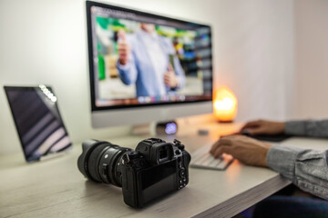 Men's hands on the keyboard. Working from home, a professional photographer edits images taken with a professional camera on a desk. The life of a photographer, love my job