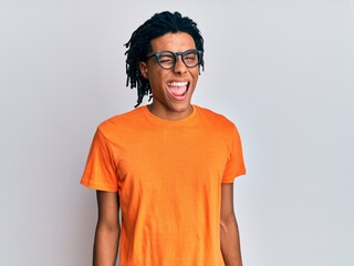 Young african american man wearing casual clothes and glasses winking looking at the camera with...