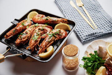 Grilled large queen shrimps with lemon and spices on the grill pan