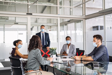 Business people wearing mask and keeping social distancing during meeting