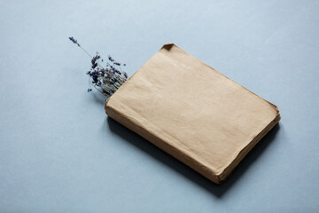 Vintage book and dry lavender flowers on gray background