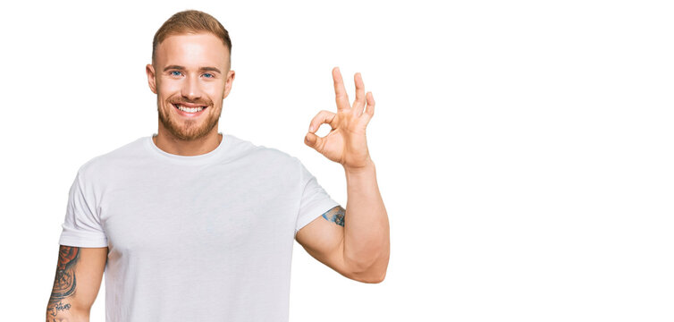 Young irish man wearing casual clothes smiling positive doing ok sign with hand and fingers. successful expression.