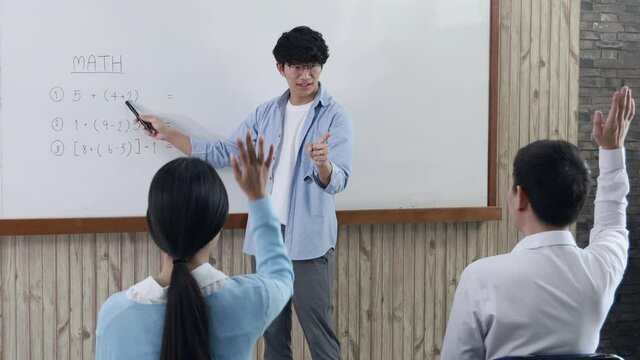 Teacher teaches students in the classroom, Students raised their hands to answer the teacher questions with confidence.