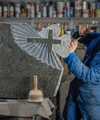Stonemasonry. Sculptor at work on a gravestone. Mason. Sculpting. Craftmanship. Hammer and chisel. 