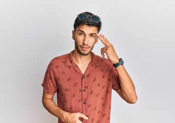 Young handsome man wearing casual summer clothes shooting and killing oneself pointing hand and fingers to head like gun, suicide gesture.