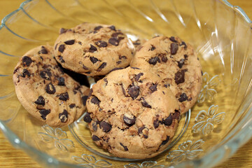 Cookies with brown chocolate in a crystal cup with wood background