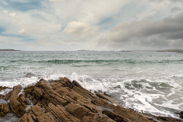 Fototapeta na wymiar Waves hit rocks. Irish nature landscape, Atlantic ocean,West coast of Ireland. Cloudy sky. Nobody.