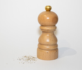 Wooden pepper mill with gound pepper beside it