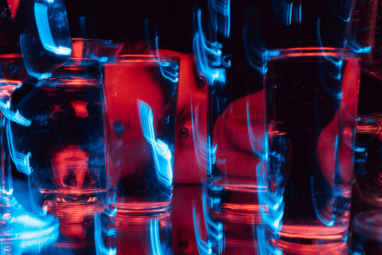 Fototapeta psychedelic strange portrait of a man looking through glasses of water with blur