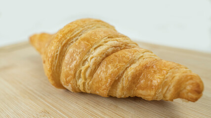 Freshly baked croissants on wooden cutting board, White Background. Crescent-shaped bread originated in France. The popular breakfast menu spread all over the world.