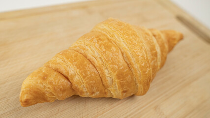 Freshly baked croissants on wooden cutting board, White Background. Crescent-shaped bread originated in France. The popular breakfast menu spread all over the world.