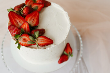 white cake with cream garnished with strawberries on a tray