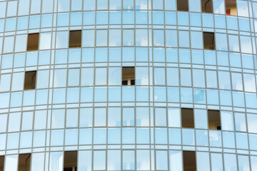 Blue modern ventilated facade with windows. Fragment of a new elite residential building or commercial complex. Part of urban real estate. Clouds reflected in windows. Photo with copy space