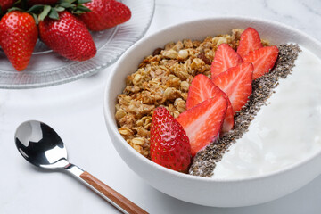 Bowl with granola, strawberry, yogurt and Chia seeds closeup. Healthy eating concept. Vegetarian breakfast.