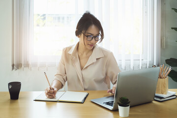 new normal, a businesswoman uses a computer to work for a company Via the internet on your desk at home