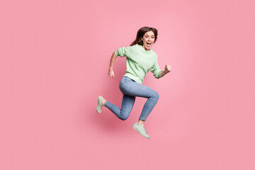 Fototapeta na wymiar Full size profile photo of brunette girl jump run yell wear lime sweater jeans sneakers isolated on pink color background