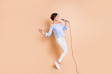Fototapeta na wymiar Full size profile side photo of young excited girl sing microphone concert crazy look empty space isolated over beige color background