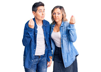 Fototapeta premium Couple of women wearing casual clothes doing italian gesture with hand and fingers confident expression