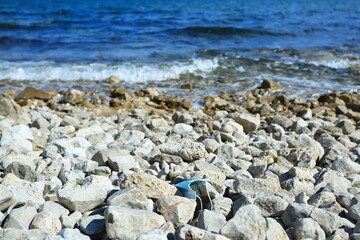 Medical mask used for COVID protection thrown on the beach resulting nature pollution and ecology problems
