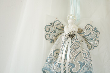 delicate silk background with handmade angel made of lace