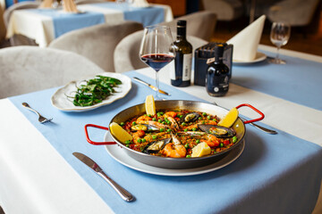 Side view on spanish seafood paella pan with mussels and shrimp