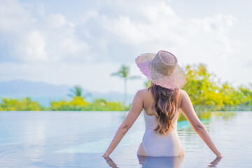 Portrait beautiful young asian woman enjoy around outdoor swimming pool with sea view