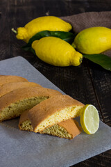 Homemade lemon cookies. Black wooden background with lemons and leaves.