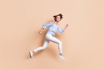 Fototapeta na wymiar Photo portrait profile of crazy woman running jumping up isolated on pastel beige colored background