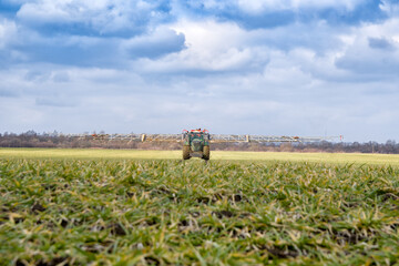Fototapeta premium tractor spraying wheat