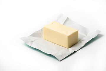 Traditional butter block unwrapped for use as a baking ingredient isolated on white background