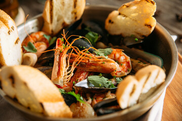 Closeup on assorted seafood basket bowl with toasted bread 